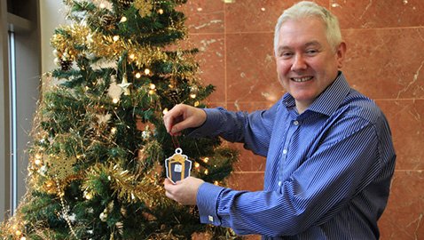 Chief Executive Peter Hill with the first charity decoration on the Head Office Christmas tree